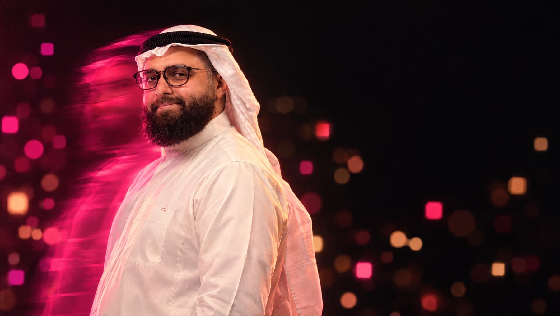 Ibrahim Shareef, founder and CEO of Itqan, in a white kandura and ghutra under rose light with square bokeh